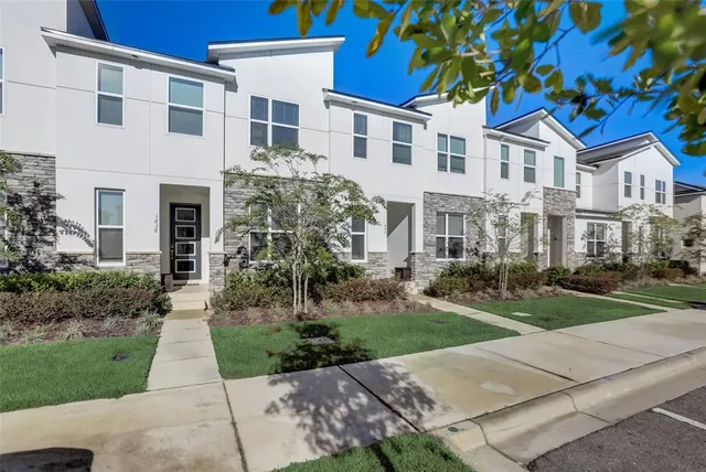 a front view of a house with a yard and trees