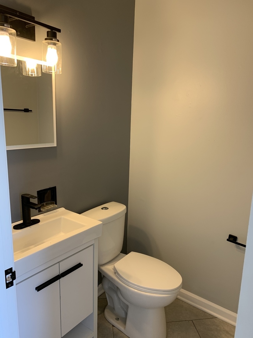 74 West 140th Street Riverdale, IL 60827 - Photo 16 of 20 a bathroom with a sink a toilet and mirror