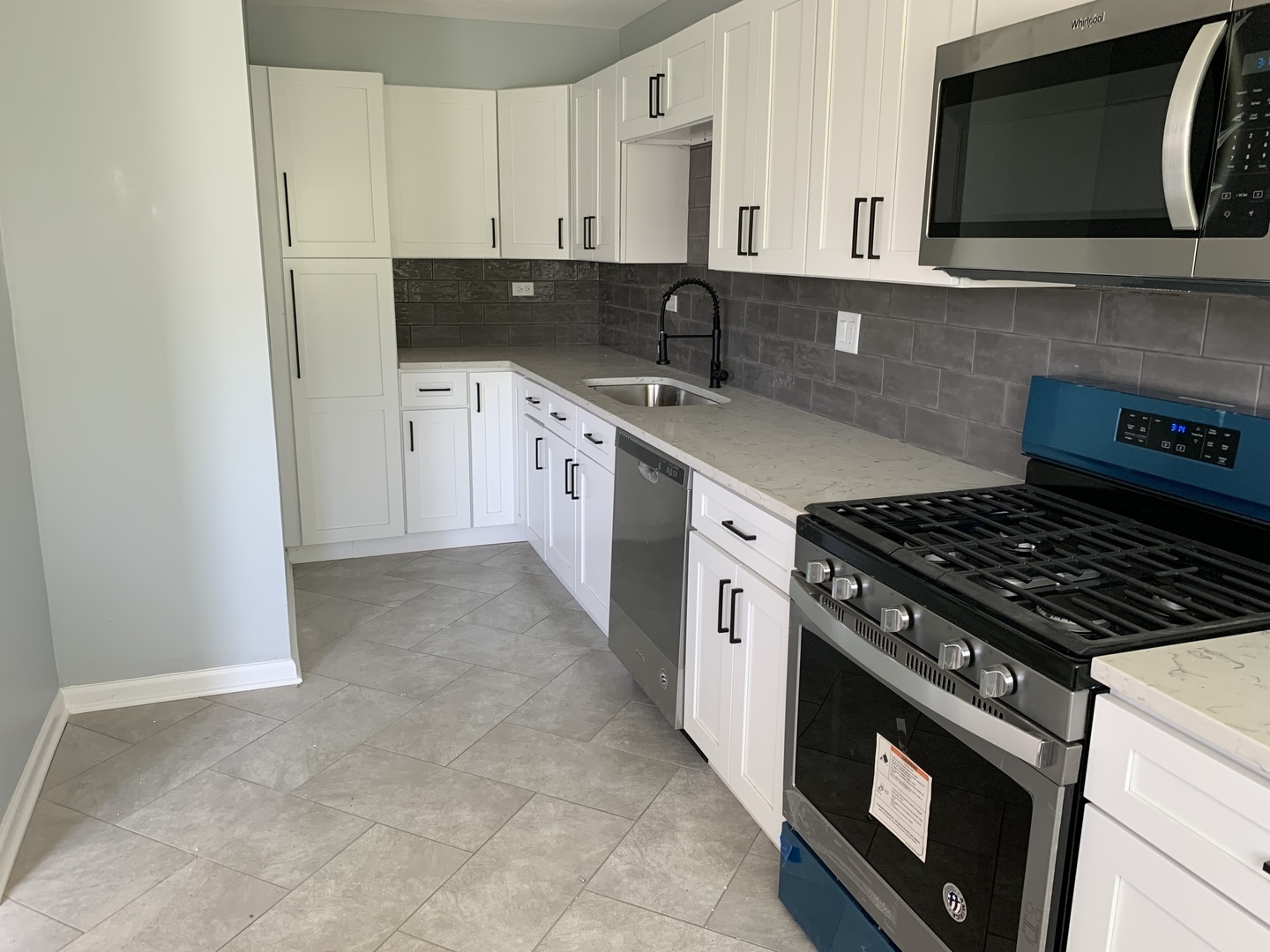 74 West 140th Street Riverdale, IL 60827 - Photo 6 of 20 a kitchen with stainless steel appliances granite countertop a sink stove and microwave