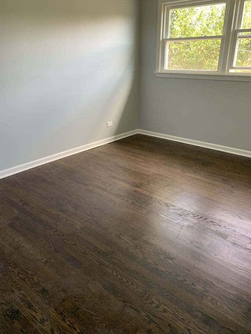 74 West 140th Street Riverdale, IL 60827 - Photo 9 of 20 an empty room with wooden floor and windows