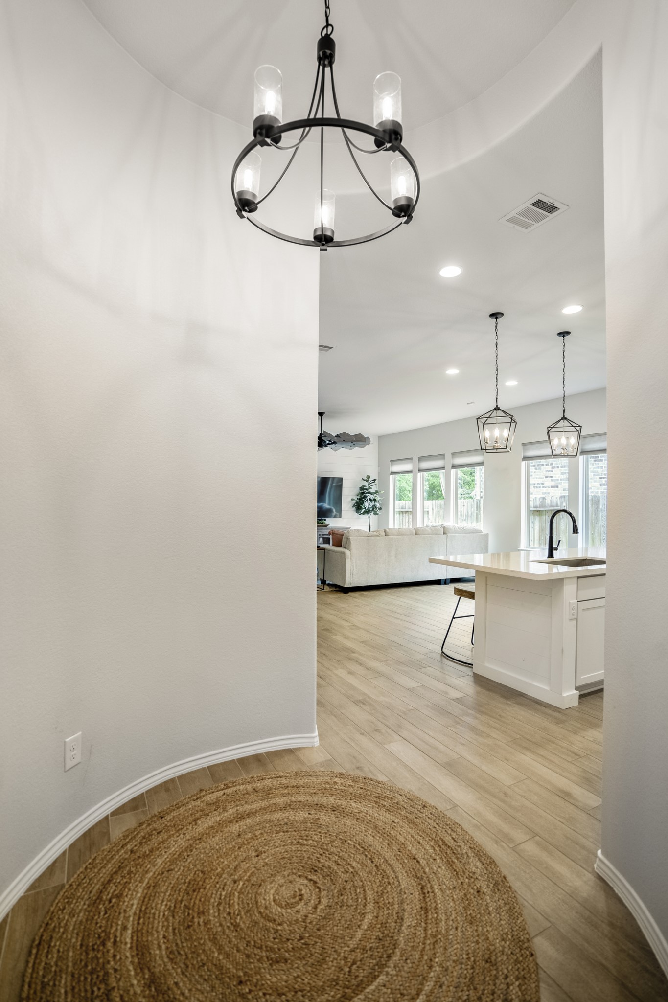 334 Topper Pines Drive Montgomery, TX 77316 - Photo 4 of 49 At the end of the foyer, centered by a wrought iron wagon wheel chandelier, is a round-a-bout style intersection that transitions us to the living spaces.