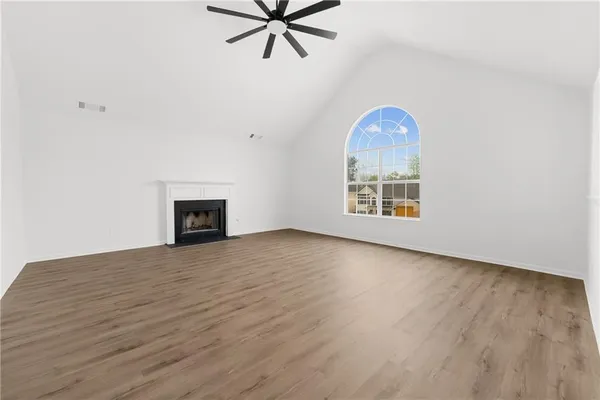 an empty room with windows and fireplace
