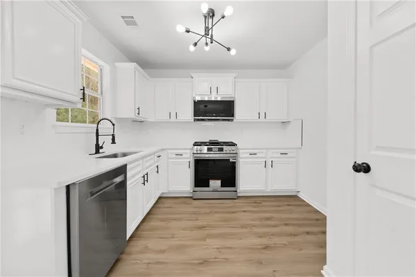 a kitchen with granite countertop a stove top oven sink and cabinets