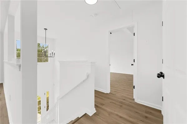 a view of hallway with stairs and wooden floor