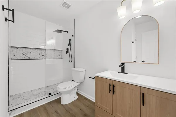 a bathroom with a granite countertop sink a toilet and a mirror