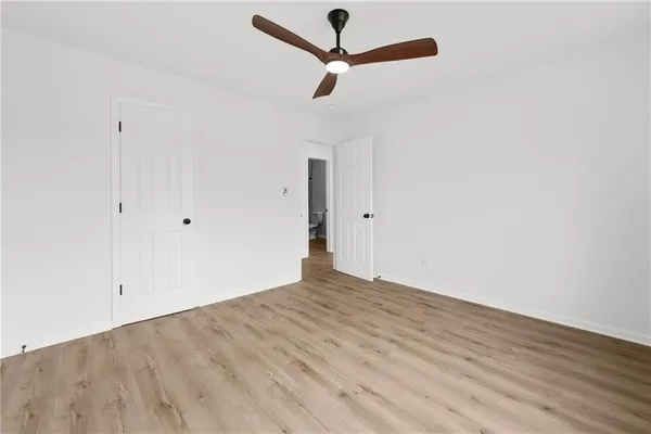a view of empty room with wooden floor