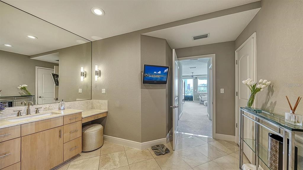 650 Golden Gate Point, Unit 602 Sarasota, FL 34236 - Photo 28 of 50 a spacious bathroom with a double vanity sink and a mirror