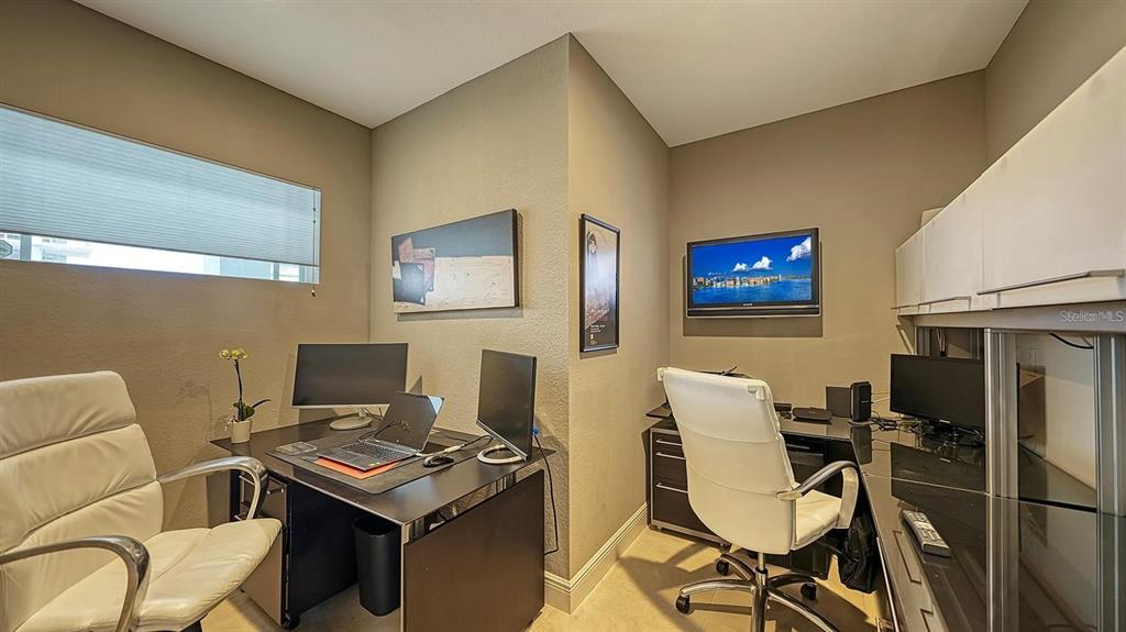 650 Golden Gate Point, Unit 602 Sarasota, FL 34236 - Photo 30 of 50 a view of a workspace with furniture and a flat screen tv