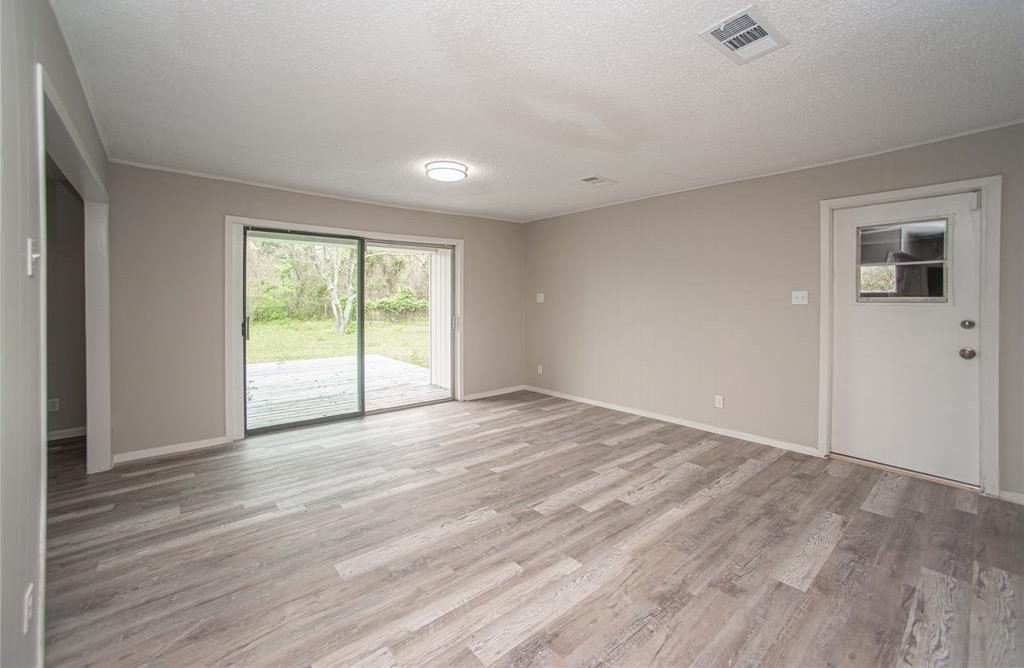 317 Pear Street La Marque, TX 77568 - Photo 7 of 18 a view of an empty room with wooden floor and a window
