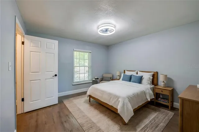 an empty room with wooden floor and window