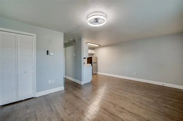 a kitchen with a refrigerator and white cabinets
