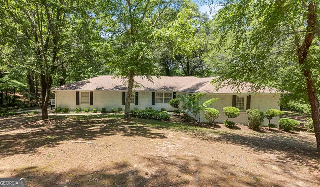 a view of a house with a yard and large tree