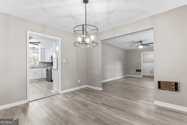 a view of a chandelier in a room with a chandelier fan and kitchen view