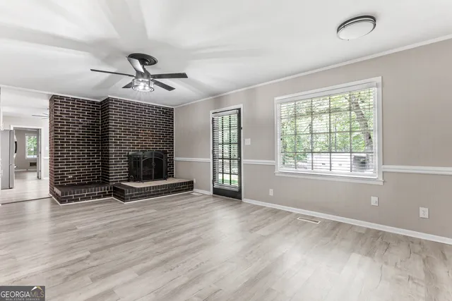 a view of empty room with wooden floor and fireplace
