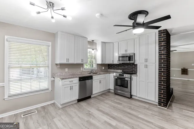 a kitchen with stainless steel appliances granite countertop a stove and a sink