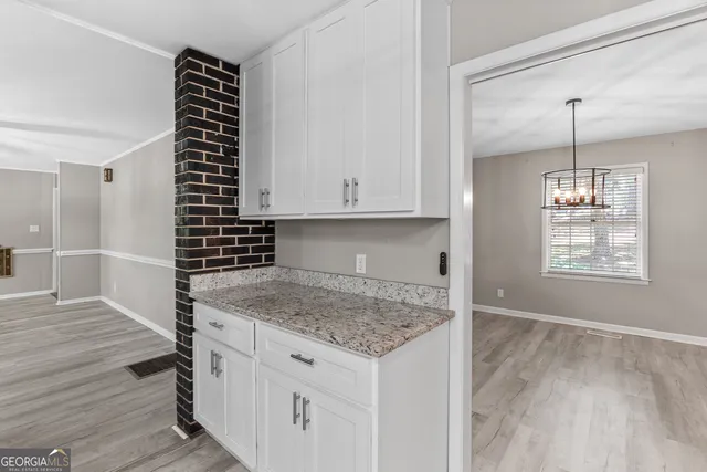 a kitchen with granite countertop a sink cabinets and wooden floor