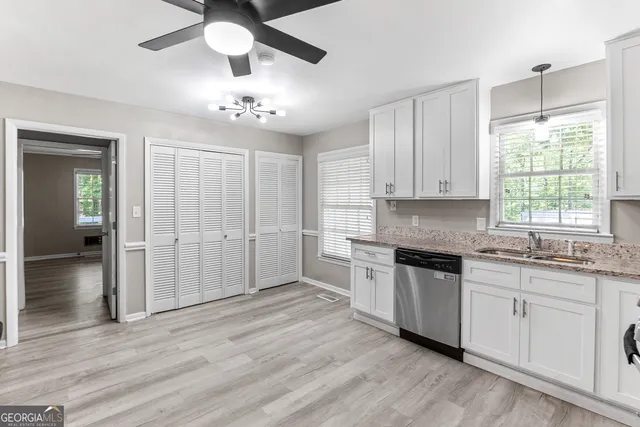 a large kitchen with granite countertop a stove sink and cabinets