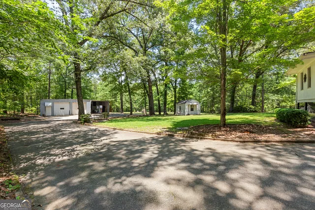 a view of a house with a big yard and palm trees
