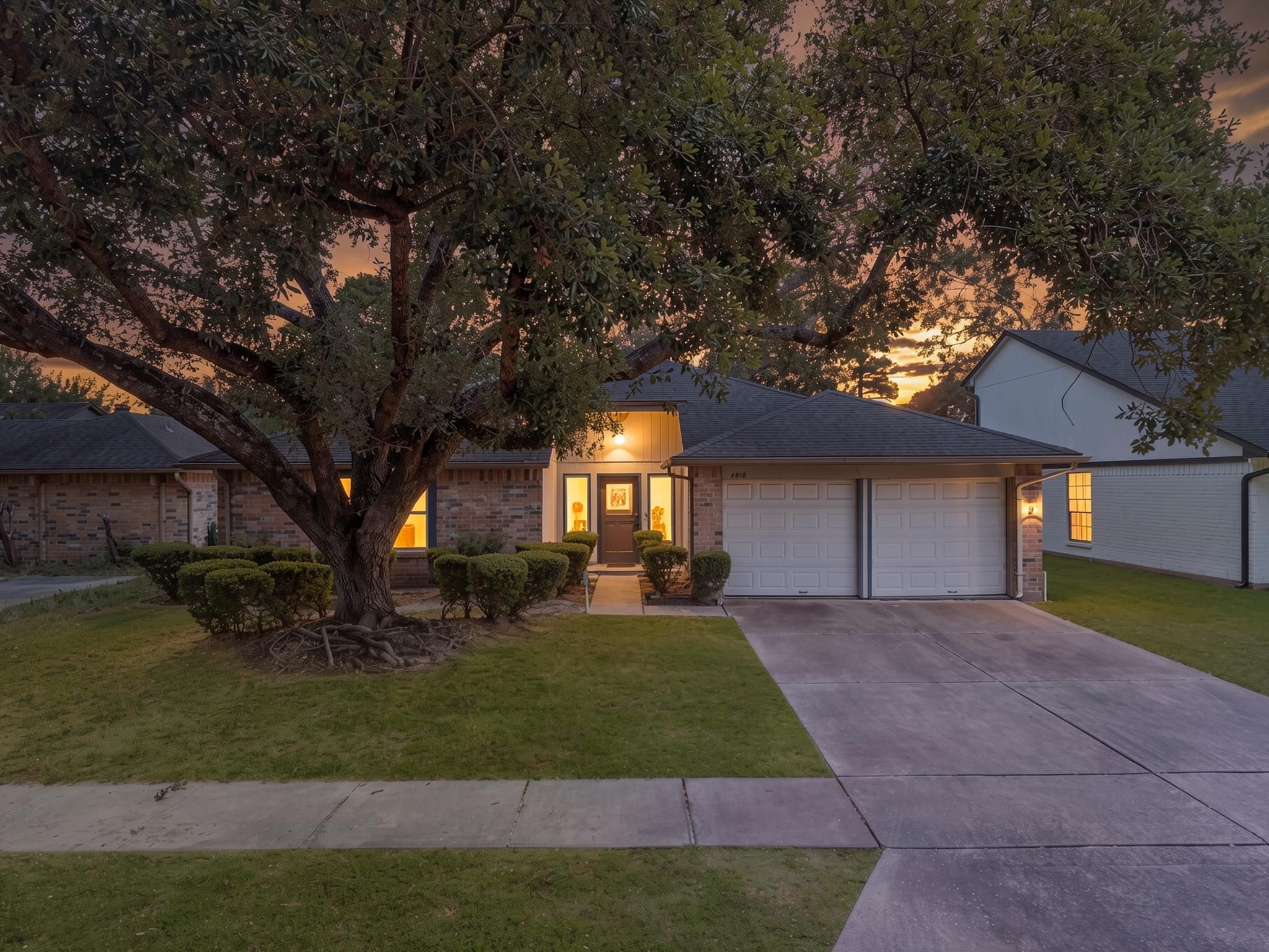 4918 Bridgemont Lane Spring, TX 77388 - Photo 1 of 15 The home presents with a traditional single-story layout, mature landscaping, and a clean front approach. The large tree, brick exterior, and wide driveway give the property a grounded neighborhood feel.