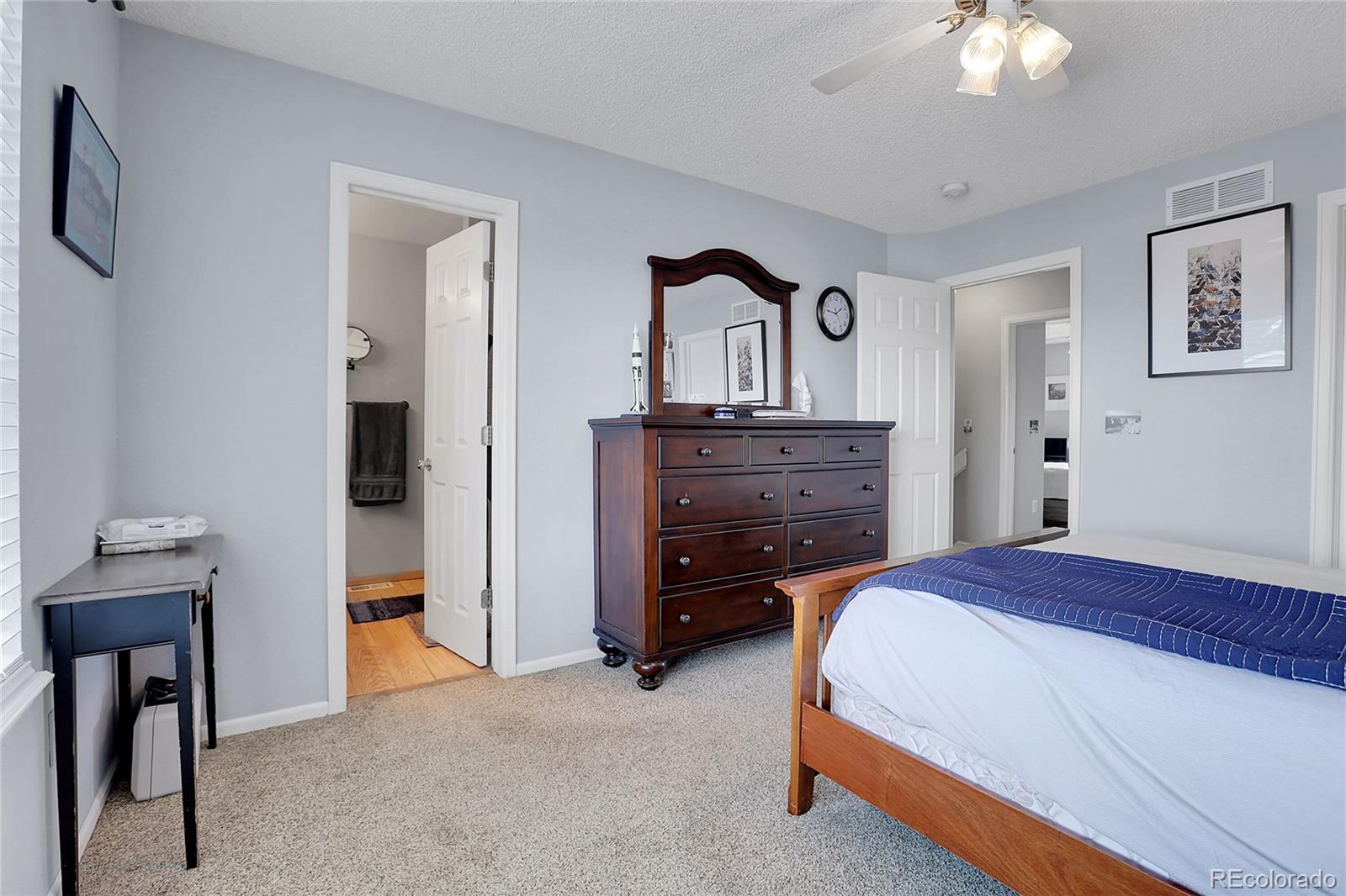 9806 South Castle Ridge Circle Highlands Ranch, CO 80129 - Photo 17 of 36 a bedroom with a bed and a chandelier