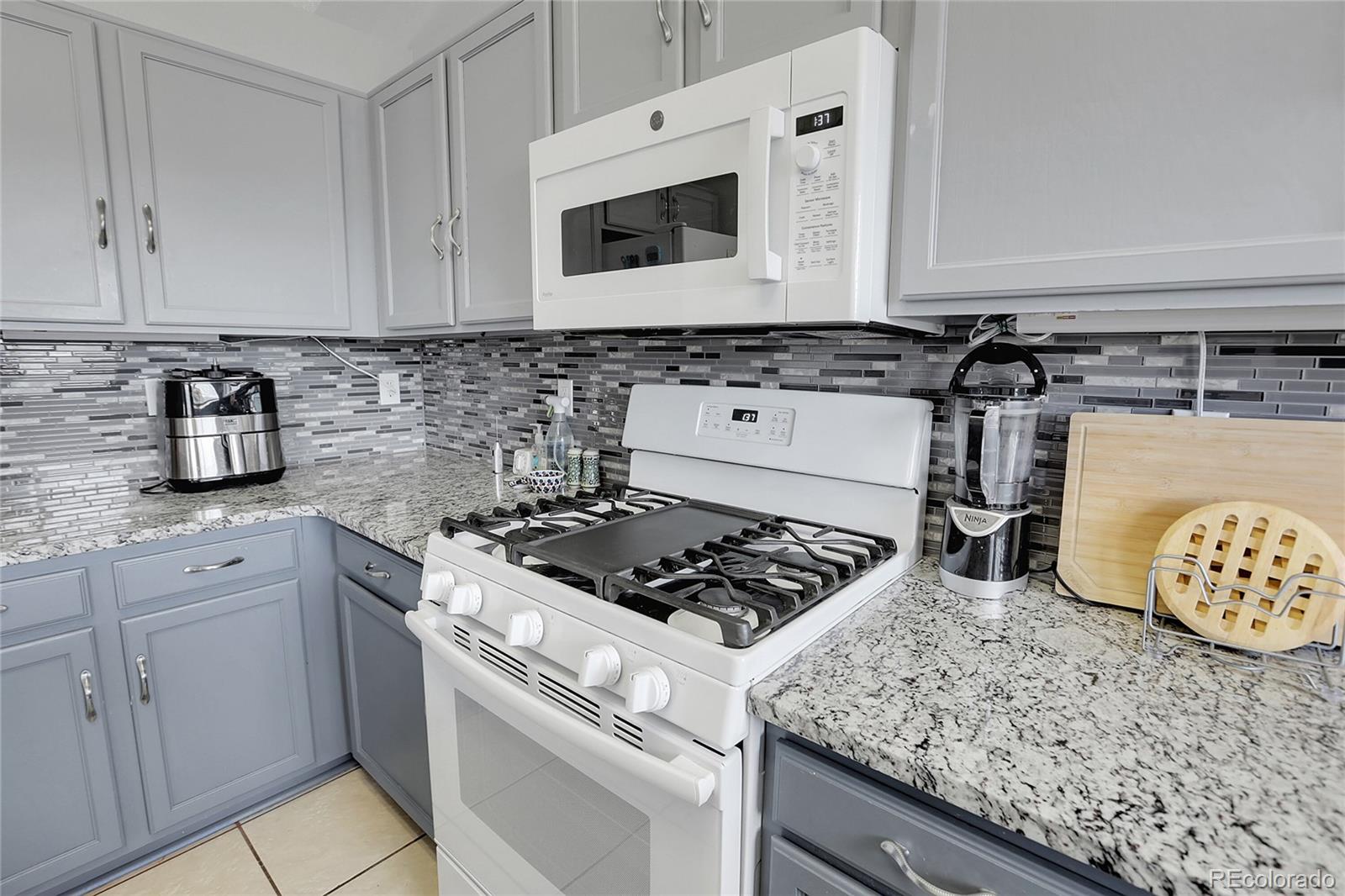9806 South Castle Ridge Circle Highlands Ranch, CO 80129 - Photo 6 of 36 a kitchen with white cabinets and appliances