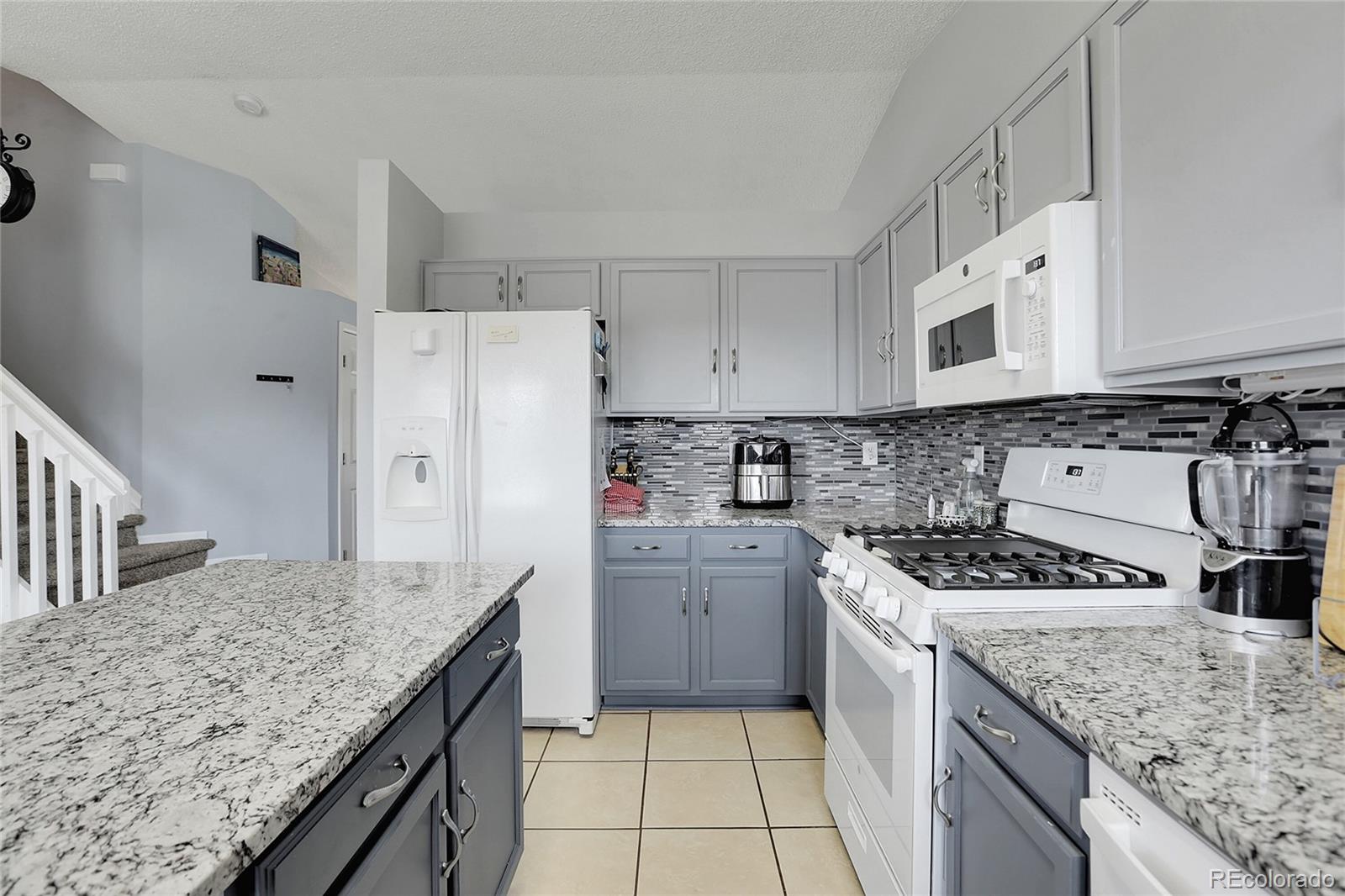 9806 South Castle Ridge Circle Highlands Ranch, CO 80129 - Photo 7 of 36 a kitchen with granite countertop a sink stove and refrigerator