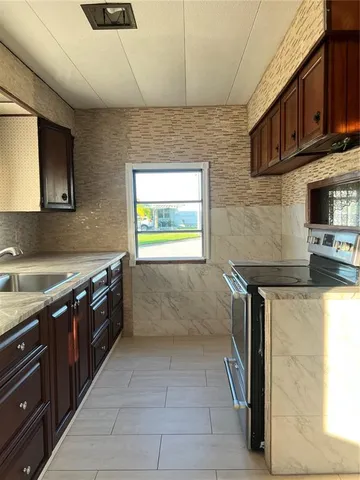 a kitchen with stainless steel appliances granite countertop a sink and a stove