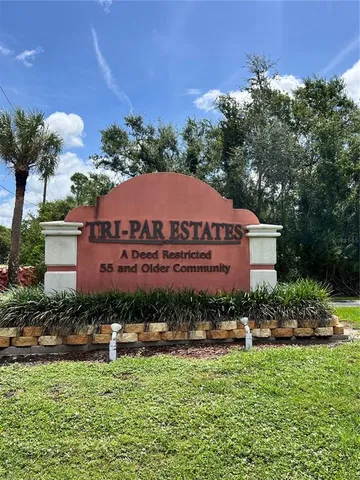 a front view of multi story residential apartment building with yard and green space