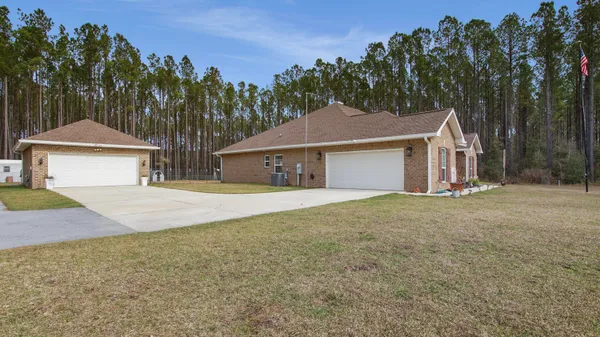 a front view of a house with yard and tree s