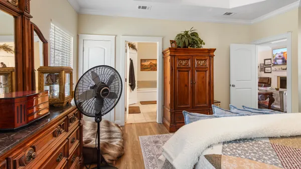 a bedroom with a bed a mirror and dresser