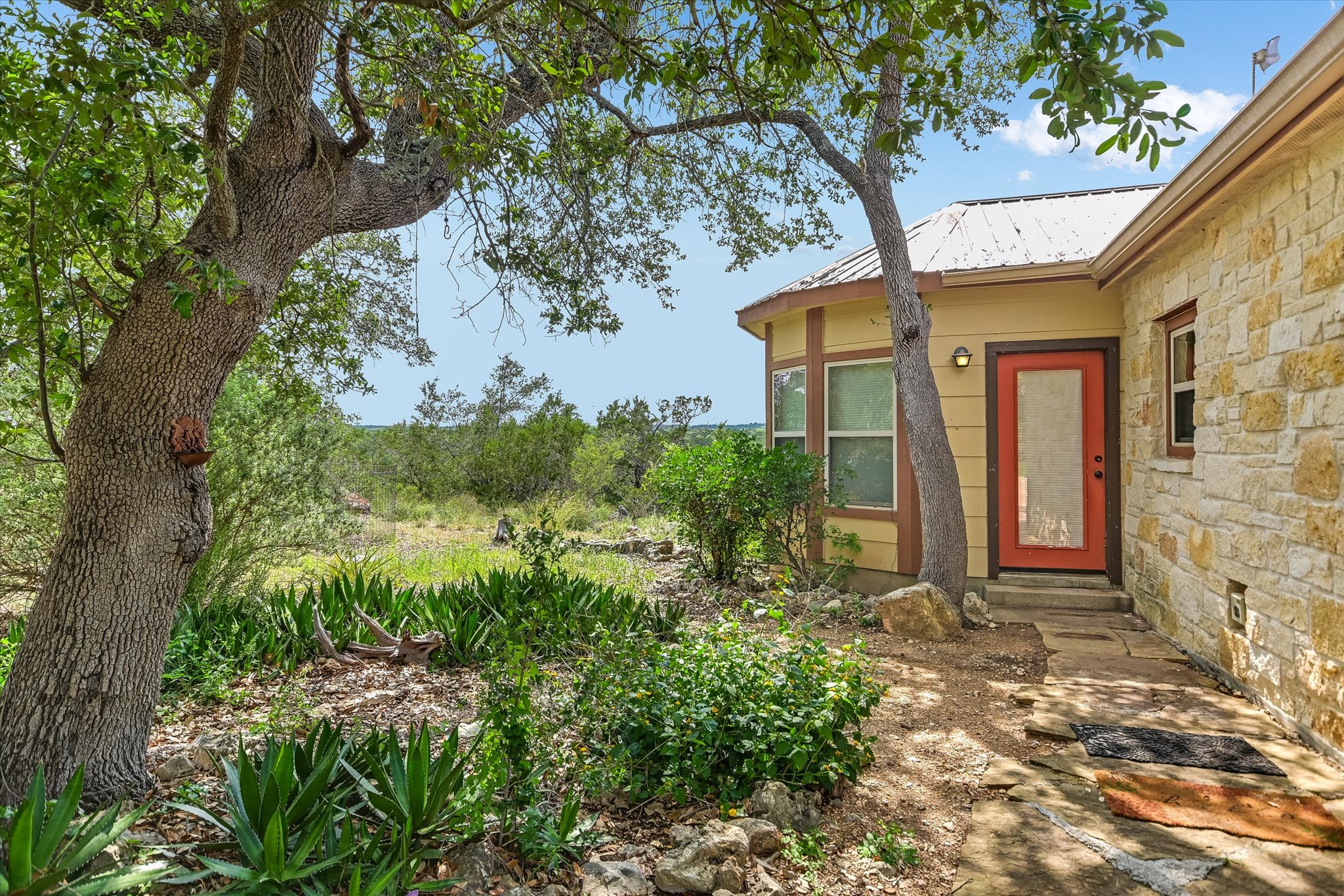 700 Cliffside Road Wimberley, TX 78676 - Photo 17 of 22 Stone veneer exterior with a metal roof