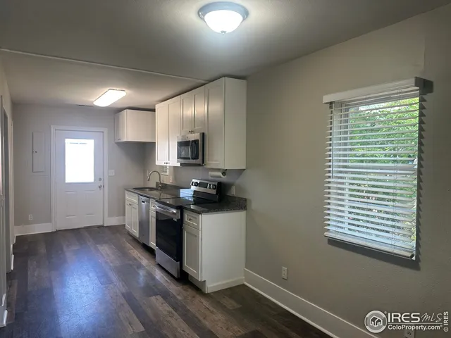 a kitchen with a sink wooden floor and a window