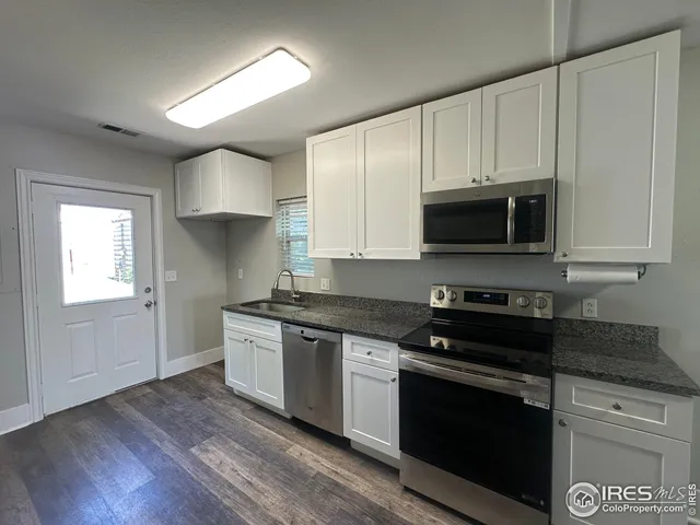 a kitchen with granite countertop a stove and a microwave