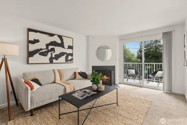 a living room with furniture a fireplace and a floor to ceiling window