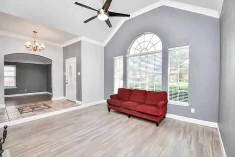 a living room with a large bed and a chandelier