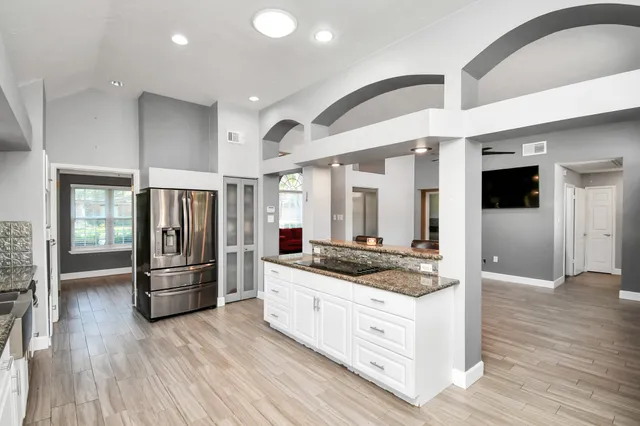 a kitchen with stainless steel appliances granite countertop a refrigerator and a stove top oven