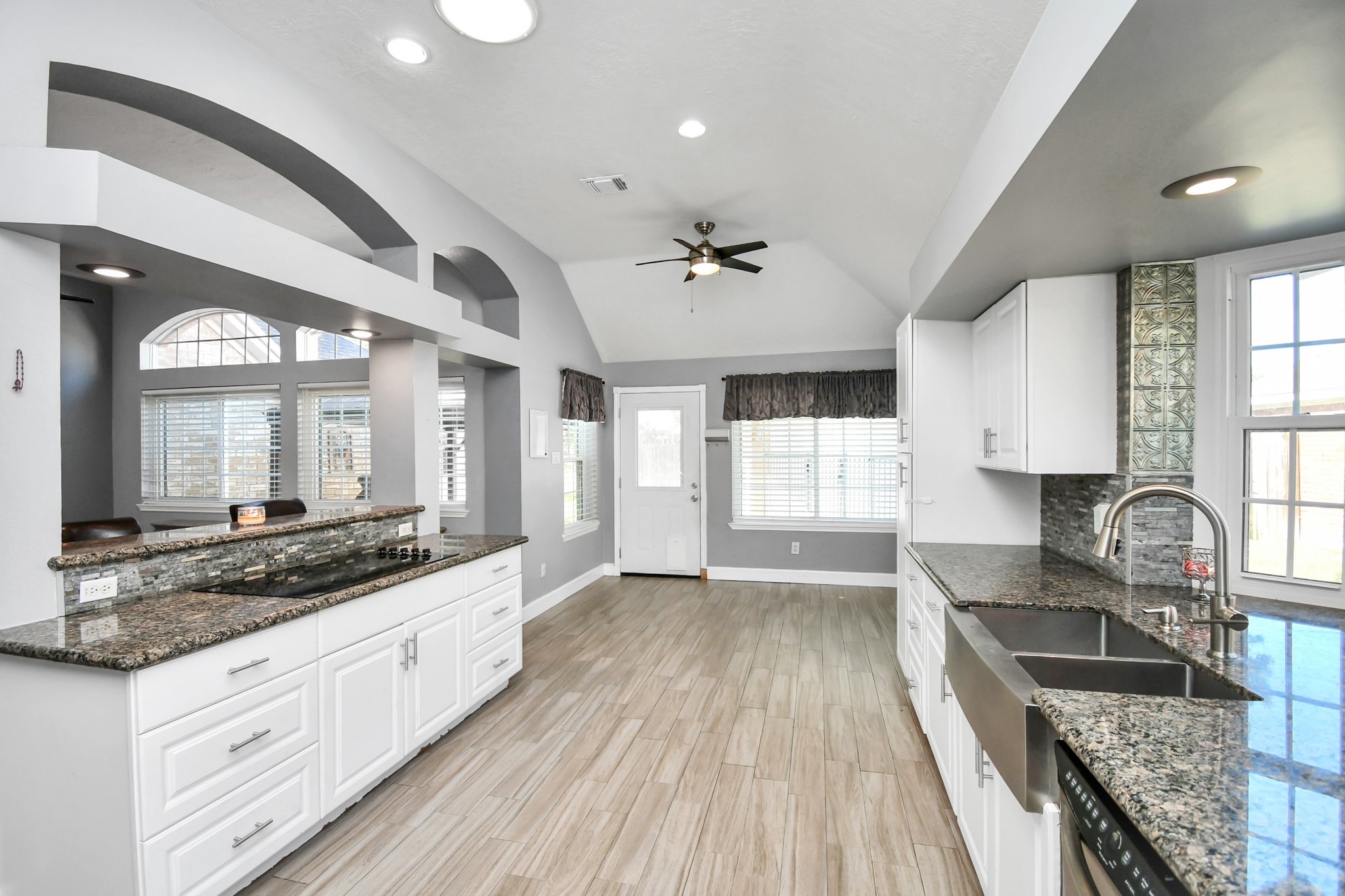 3642 Postwood Drive Spring, TX 77388 - Photo 28 of 43 a kitchen with granite countertop a stove a sink and white cabinets with wooden floor