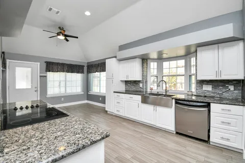 a kitchen with a stove a sink a refrigerator and cabinets