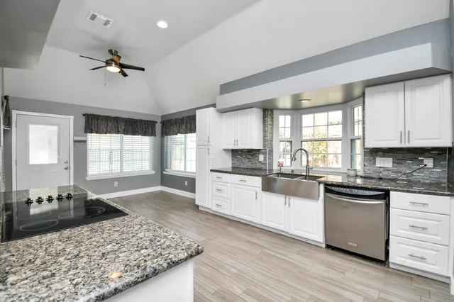 a kitchen with a stove a sink a refrigerator and cabinets