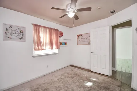 a view of an empty room with window and cabinet