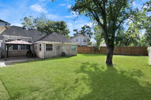 a view of a house with backyard and a tree