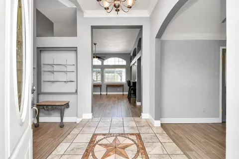 a view of a hallway with wooden floor and a living room