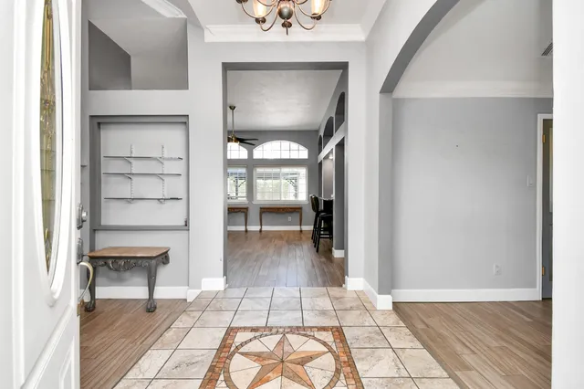 a view of a hallway with wooden floor and a living room