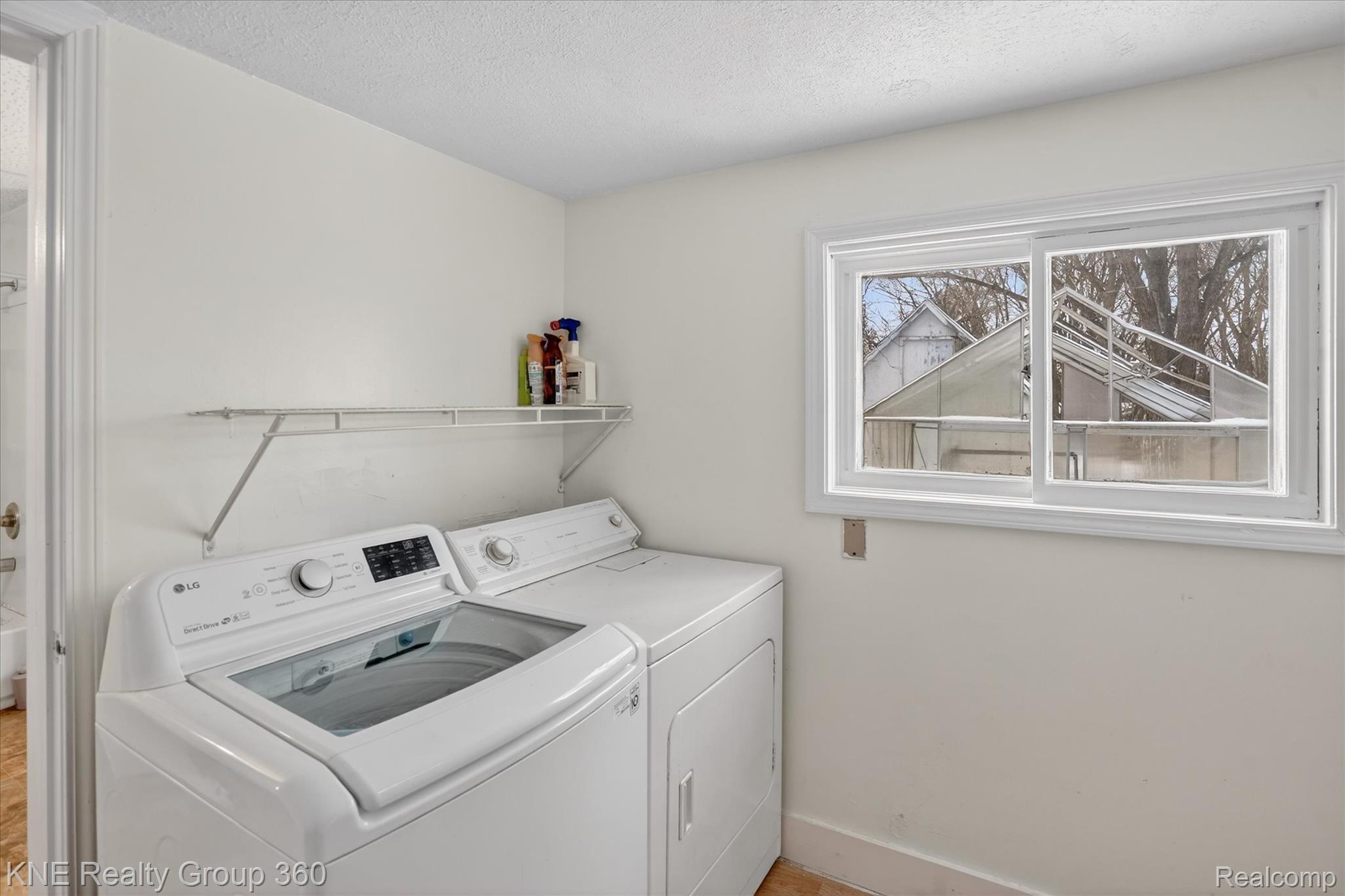 4928 Hughes Road Lansing, MI 48910 - Photo 20 of 35 Laundry room featuring separate washer and dryer and a textured ceiling