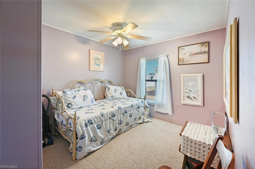 192 Oceans Boulevard, Unit 192 Naples, FL 34104 - Photo 13 of 26 a bedroom with a bed and a chandelier