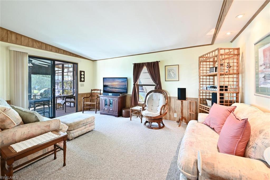 192 Oceans Boulevard, Unit 192 Naples, FL 34104 - Photo 5 of 26 a living room with furniture a large window and a flat screen tv