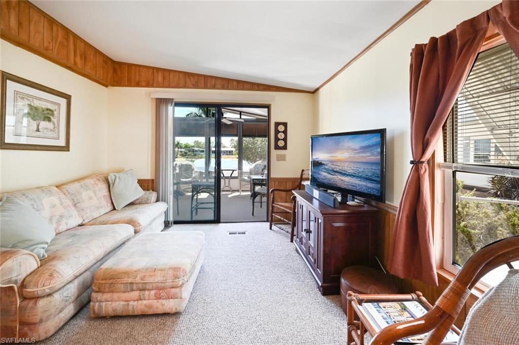 192 Oceans Boulevard, Unit 192 Naples, FL 34104 - Photo 6 of 26 a living room with furniture a flat screen tv and large window