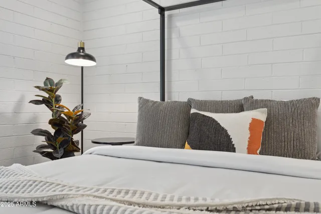 a bedroom with a bed and a potted plant