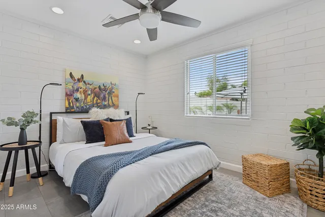 a bedroom with a bed and a painting on the wall