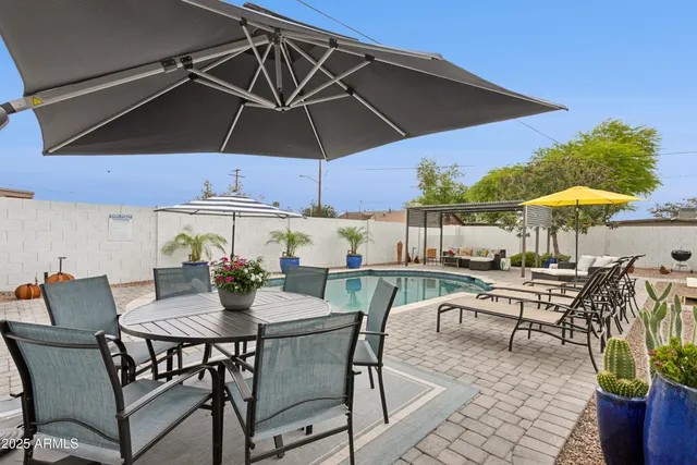 a view of patio with chairs and table under an umbrella